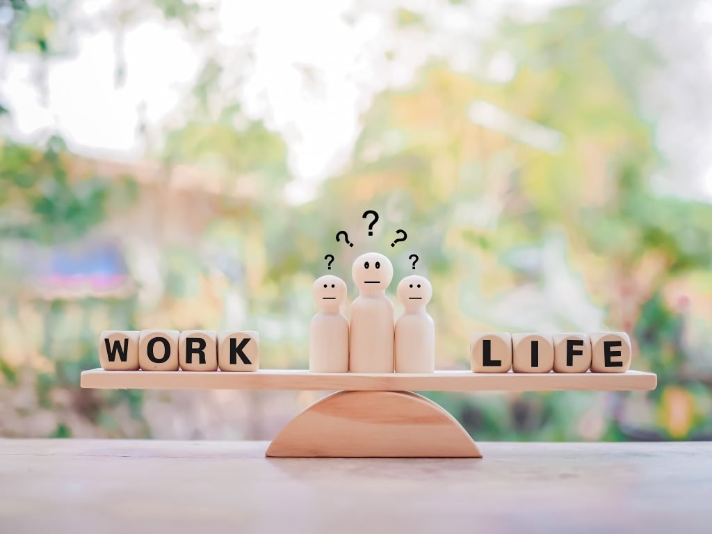 Trochę teorii – o work-life balance 3 Ilustracja drewnianej wagi, obrazującej work-life balance.