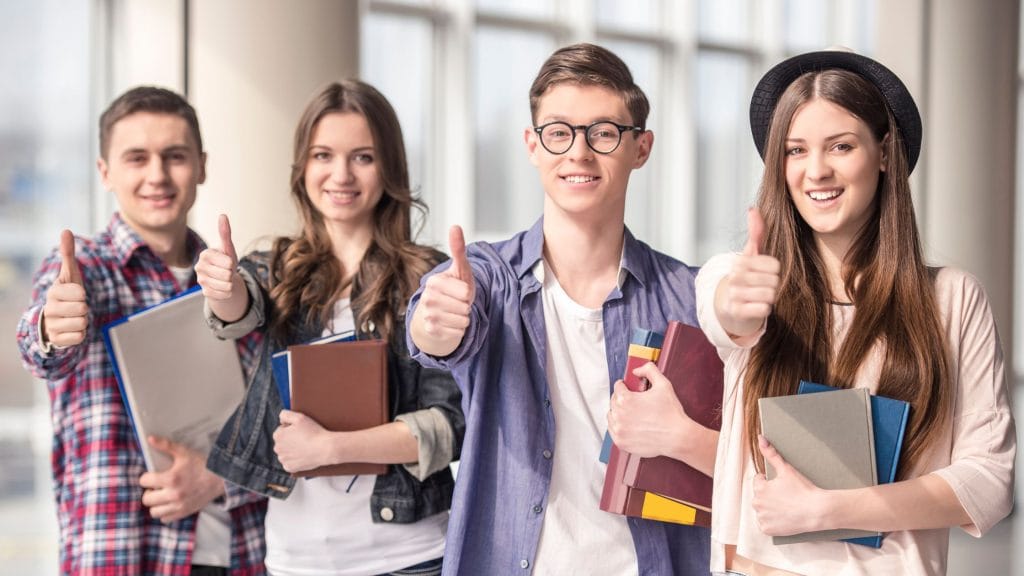 Studia dzienne czy zaoczne? Która opcja jest lepsza dla Ciebie? 11 uśmiechnięci młodzi ludzie mężczyźni i kobiety w roli przyszłych studentów